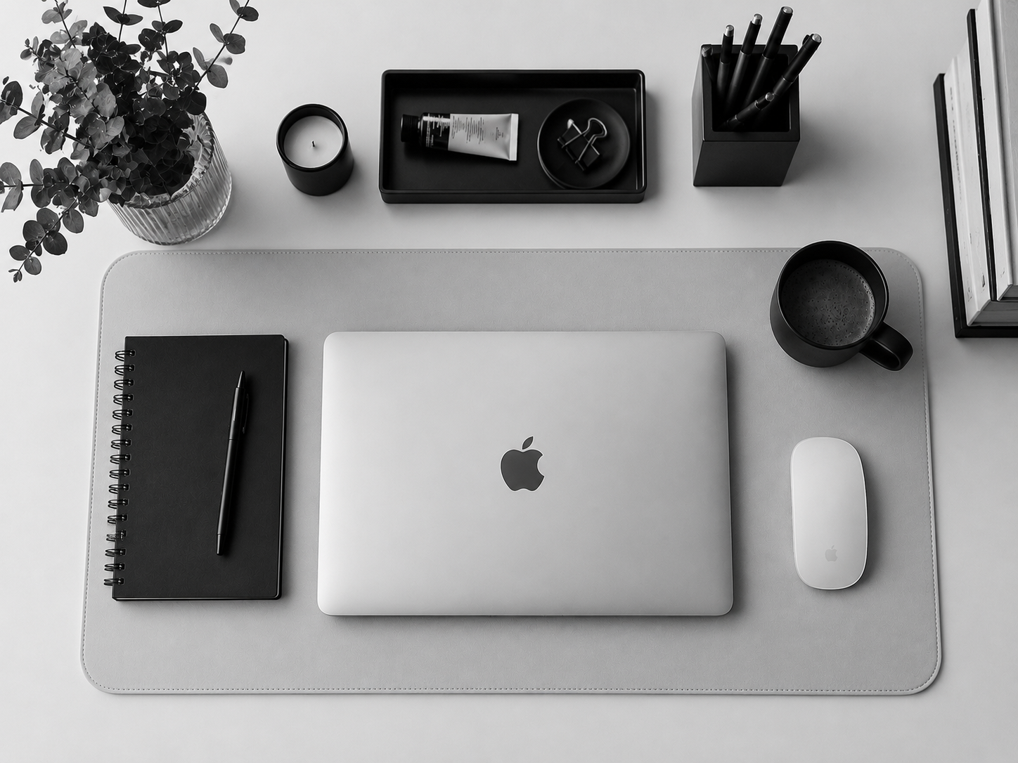 Escritorio creativo en blanco y negro con laptop, cafe y libros